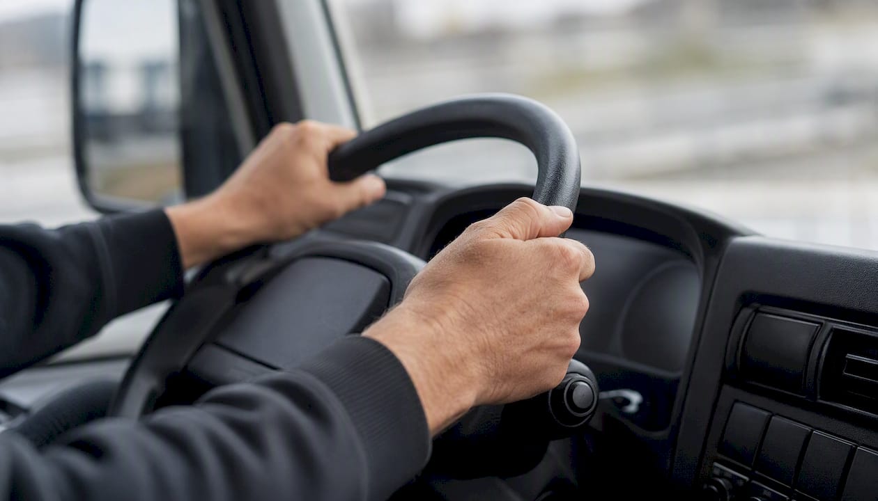 De bestuurder houdt het stuur stevig vast in een zakelijke auto.