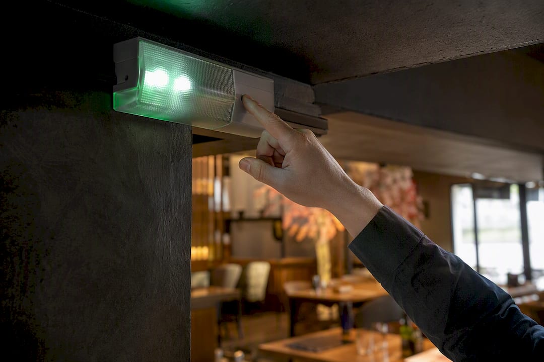 Iemand controleert de noodverlichting in de keuken.